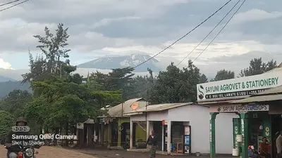 a snow covered mountain in the distance behind a building at West Kilimantis in Bondeni Boloti