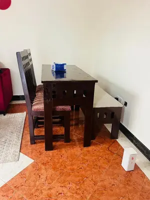 a wooden table and two chairs in a room at Osim Homes in Arusha