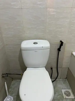 a bathroom with a white toilet in a room at Osim Homes in Arusha