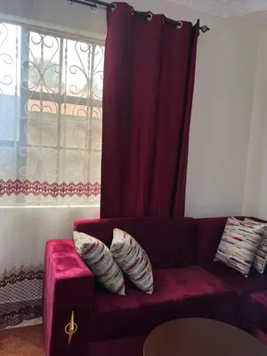 a red couch with pillows on it in a living room at Osim Homes in Arusha