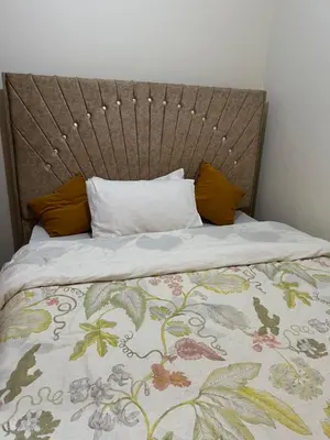 a bed with a headboard and pillows on it at Osim Homes in Arusha