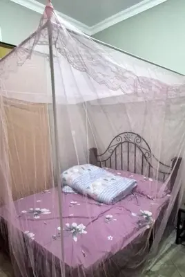 a bed covered in mosquito nets in a room at World Heart Africa Experience in Arusha