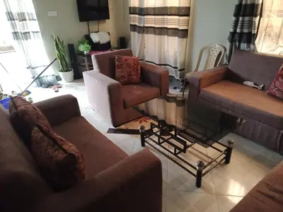 a living room with couches and chairs and a tv at World Heart Africa Experience in Arusha