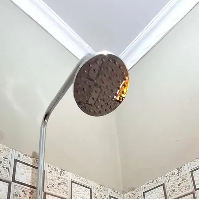 a shower head hanging from the ceiling of a bathroom at World Heart Africa Experience in Arusha
