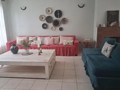 a living room with a red couch and a table at LAVENDER Residence Arusha in Arusha