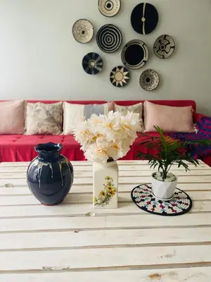a living room with a couch and a table with flowers at LAVENDER Residence Arusha in Arusha