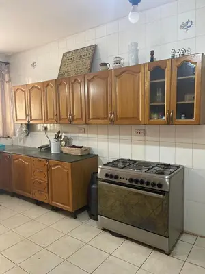 a kitchen with a stove and wooden cabinets at LAVENDER Residence Arusha in Arusha