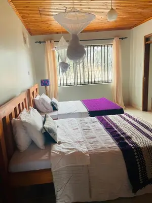 a large bed in a bedroom with a window at LAVENDER Residence Arusha in Arusha