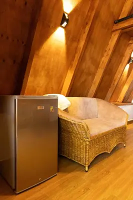 a wicker chair sitting in the middle of a attic at A-Frame tiny house in Arusha