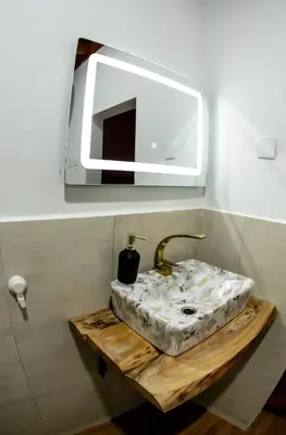 a bathroom with a sink and a mirror at A-Frame tiny house in Arusha