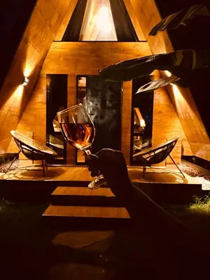a wine glass sitting on top of a table at A-Frame tiny house in Arusha