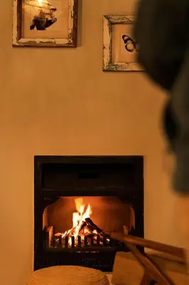 a person is standing in front of a fireplace at Koroi Forest Camp in Arusha