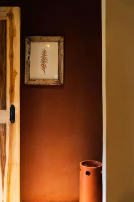 a picture of a plant on a wall with a vase at Koroi Forest Camp in Arusha