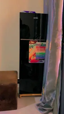 a black refrigerator in a room next to a wall at New blood home in Arusha