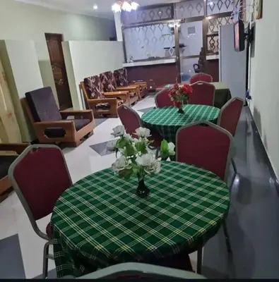 a room with two green tables with flowers on it at Otakef Motel in Arusha