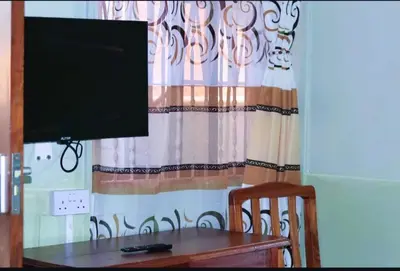 a television sitting on top of a table in front of a window at Otakef Motel in Arusha