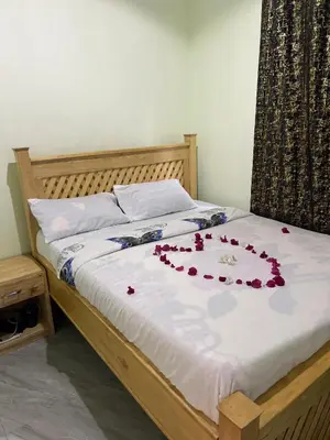 a bed with red flowers on top of it at Upendo Moja House in Nkoanrua