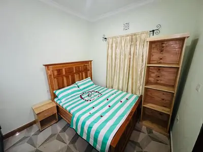 a small bedroom with a bed and a book shelf at Upendo Moja House in Nkoanrua