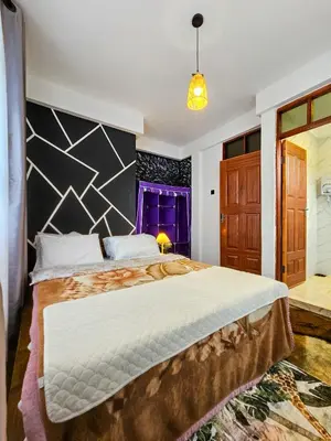 a bedroom with a large bed and a purple window at Fly Africa village 3 in Arusha