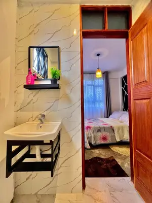a bathroom with a sink and a bed at Fly Africa village 3 in Arusha
