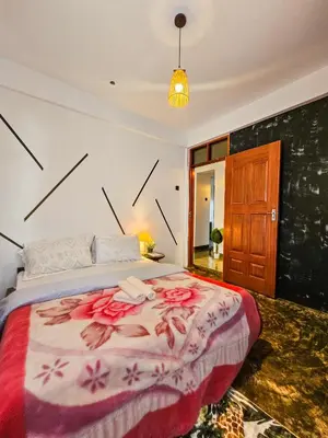 a bedroom with a large bed with flowers on it at Fly Africa village 3 in Arusha