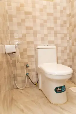 a bathroom with a toilet with a hose at Lavish Homestay in Msaranga