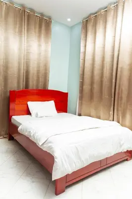 a bed with a red headboard in a bedroom at Lavish Homestay in Msaranga
