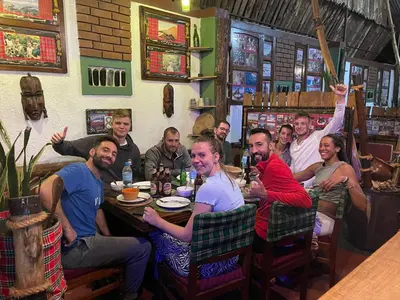 a group of people sitting at a table in a restaurant at I LOVE AFRICA VILLAs in Moshi