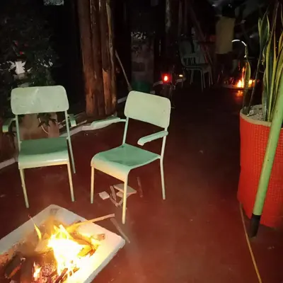 two chairs and a fire in a room at I LOVE AFRICA VILLAs in Moshi