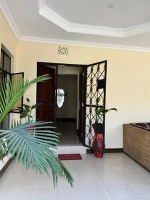 an open door into a room with a plant at Maasai house in Arusha