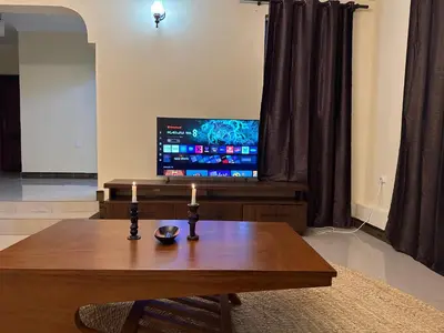 a living room with a table and a tv at Maasai house in Arusha