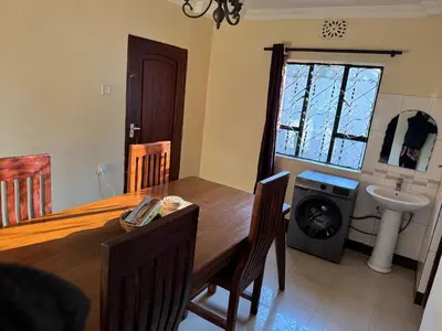 a dining room with a table and a sink at Maasai house in Arusha