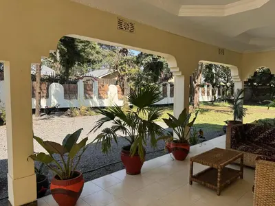 a porch with potted plants and a couch and a table at Maasai house in Arusha