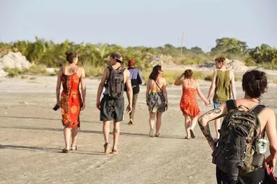 a group of people walking down the beach at White House Hostels - Arusha in Arusha