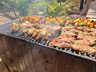 a grill with meat and vegetables on it at White House Hostels - Arusha in Arusha
