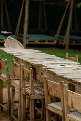 a wooden table and some chairs and a table and chairs at White House Hostels - Arusha in Arusha
