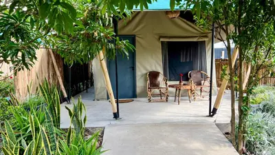 a tent with two chairs and a table in front of it at Uyoga House in Arusha