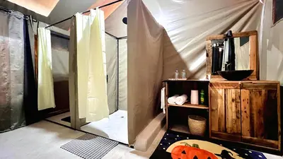 a room with a tent with a table and a shelf at Uyoga House in Arusha