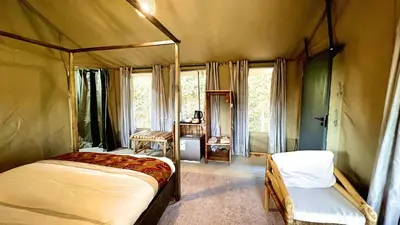 a bedroom with a canopy bed and a chair at Uyoga House in Arusha