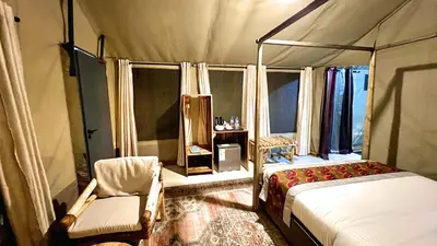 a bedroom with a canopy bed and a chair at Uyoga House in Arusha