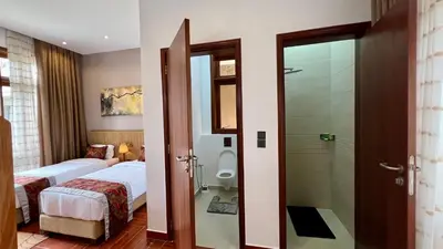 a bathroom with a bed and a toilet in a room at Uyoga House in Arusha