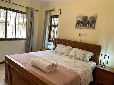 a bedroom with a large bed with a wooden frame at Emmalanta Homes in Arusha