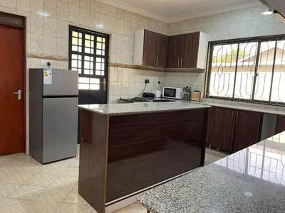 a kitchen with a refrigerator and a counter top at Emmalanta Homes in Arusha