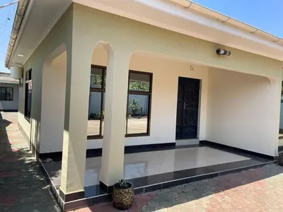 a white building with a courtyard with a potted plant at Emmalanta Homes in Arusha