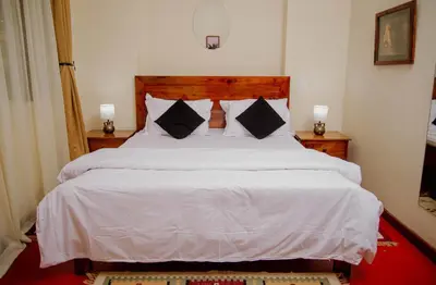 a bedroom with a large bed with white sheets and pillows at Protea House in Marombosa