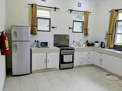 a kitchen with a refrigerator and a stove top oven at Protea House in Marombosa
