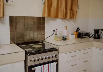 a kitchen with a stove and a counter top at Protea House in Marombosa