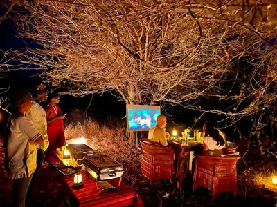 a group of people standing around a table with candles at Furaha Luxury Lodge in Mto wa Mbu