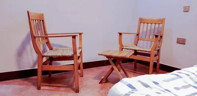two wooden chairs and a table in a room at Given House in Tuvaila