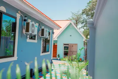 a blue house with a fence in front of it at Avek Home Stay Ngorongoro Room in Uru